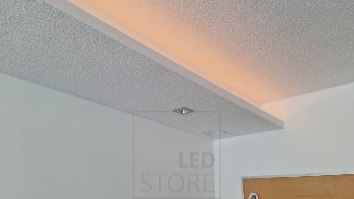 Une étagère abaissée sur les bords d'une pièce avec un éclairage indirect par une bande LED. L'étagère est également équipée de spots Fixed Cant en aluminium brossé. Ledstore.fi